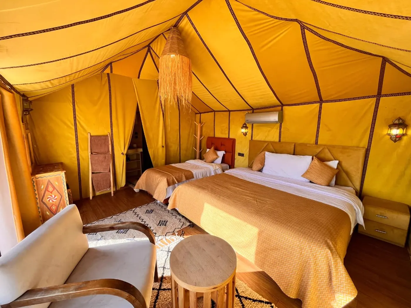 Interior de una tienda de Merzouga Glamping con dos camas y decoración marroquí